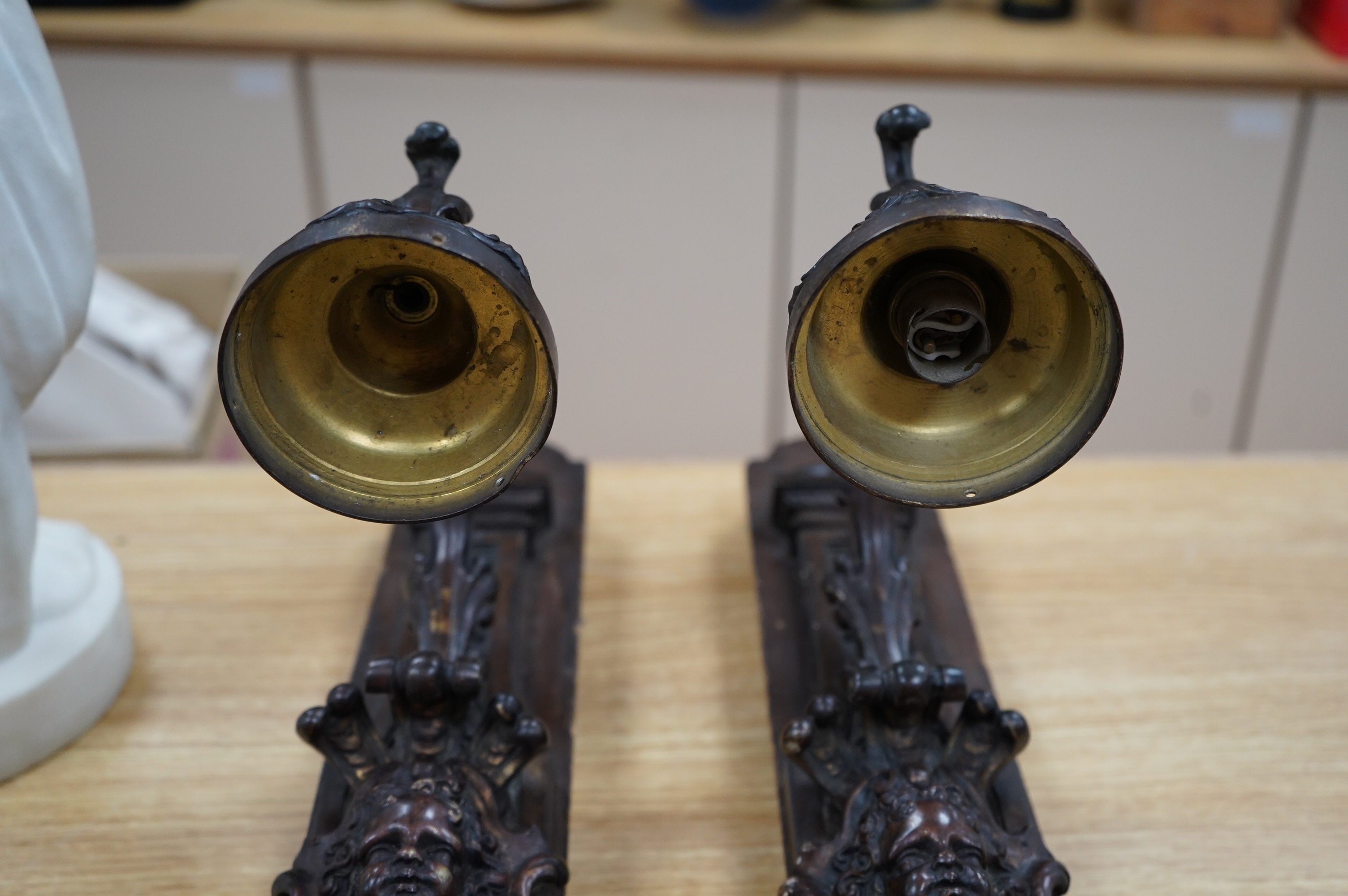 A pair of French bronze wall lights, c.1900 decorated with masks, mounted on wooden plinths, 54cm high. Condition - poor to fair